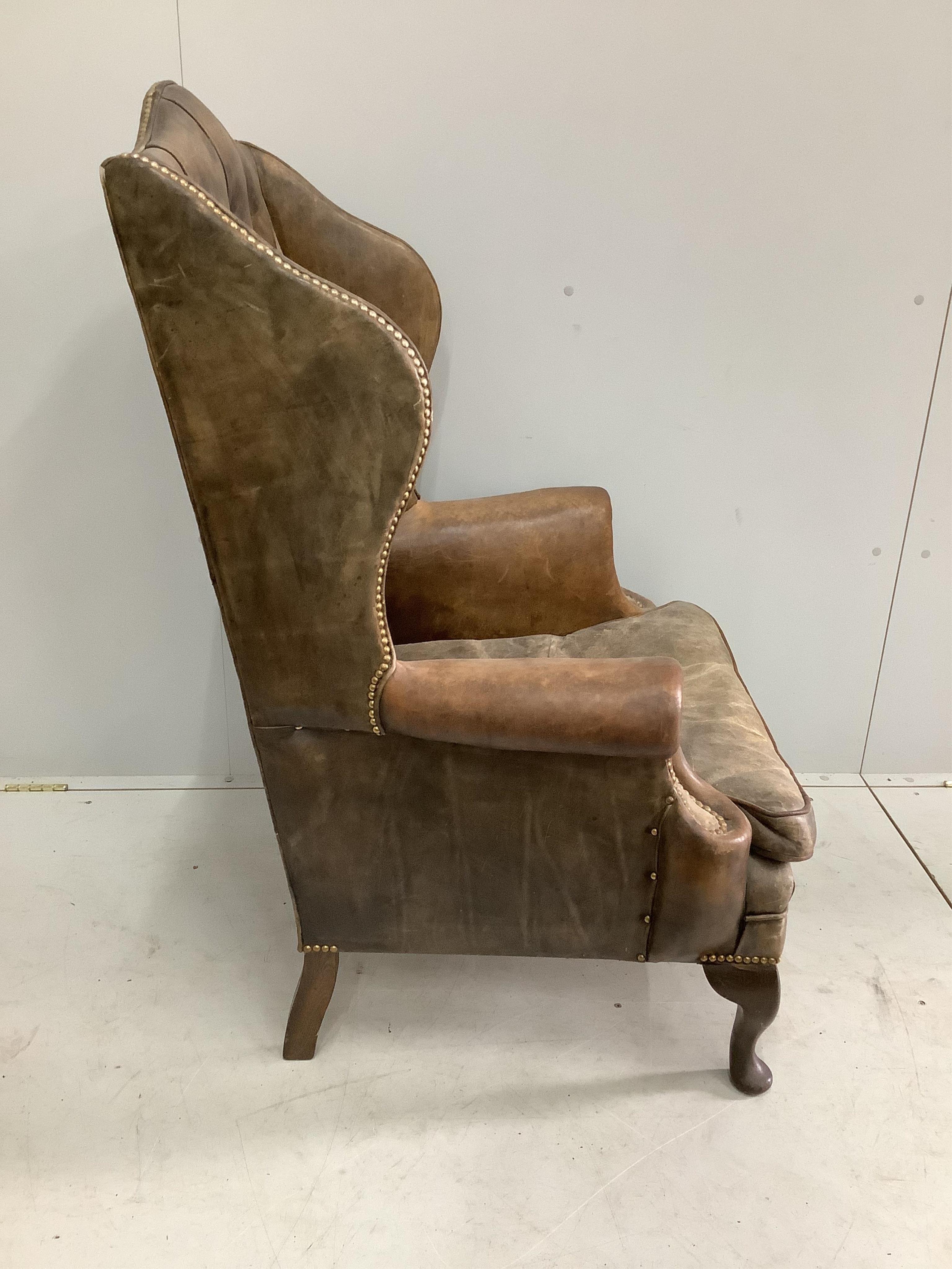 A Victorian style leather button back brown leather wing armchair, width 78cm, depth 70cm, height 114cm